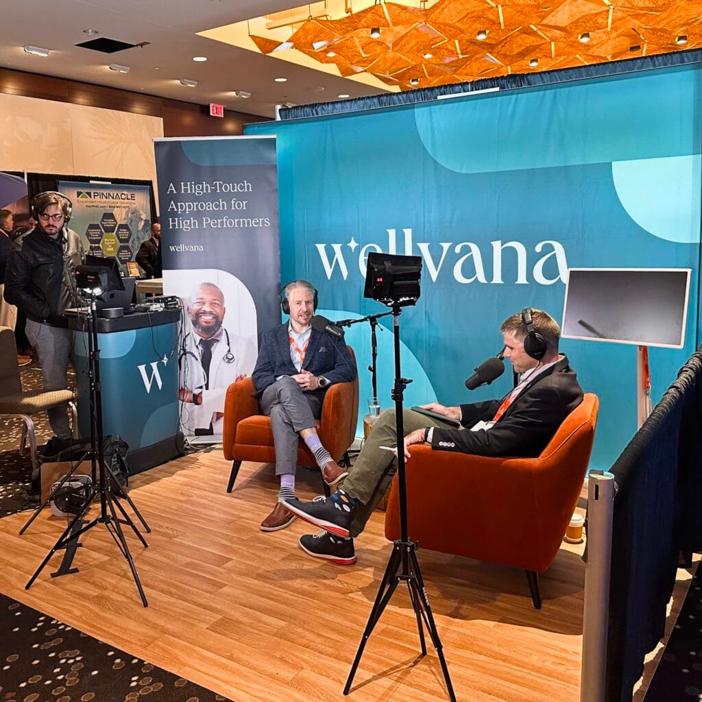 Interview in the trade show booth with studio lights, headphones, and large microphones